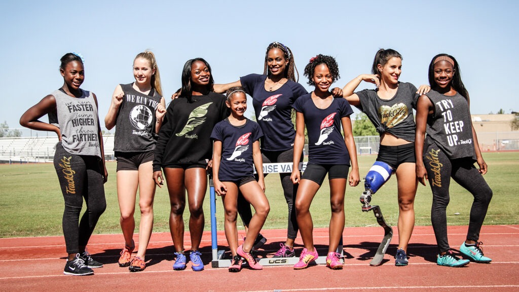 A number go girls, including TrackGirlz founder, Mechelle Freeman posing on the track