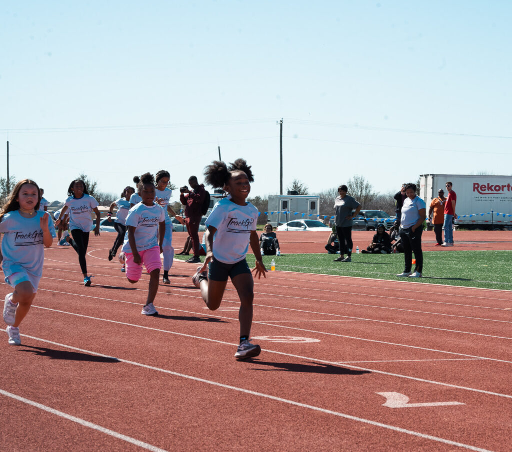 Girls running on a track in TrackGirlz shirts