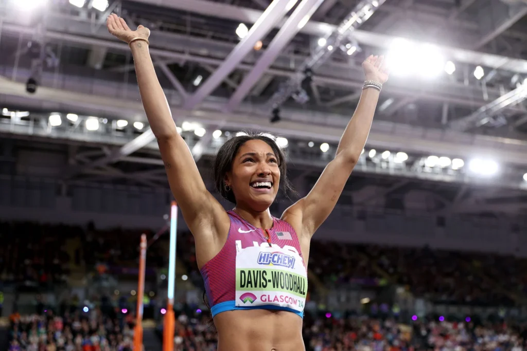 Davis-Woodhall holds her hands up in the air after a jump at the World Championships 