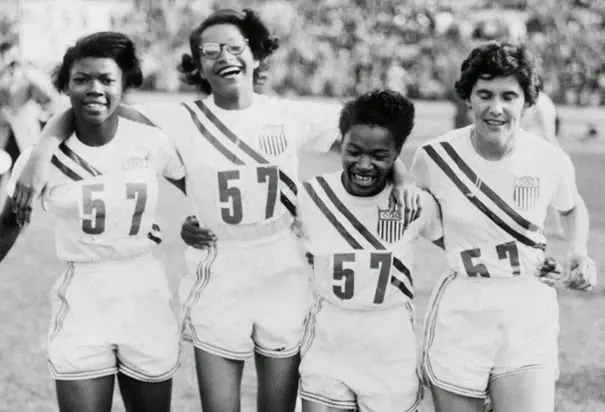 Relay team stands with arms around one another