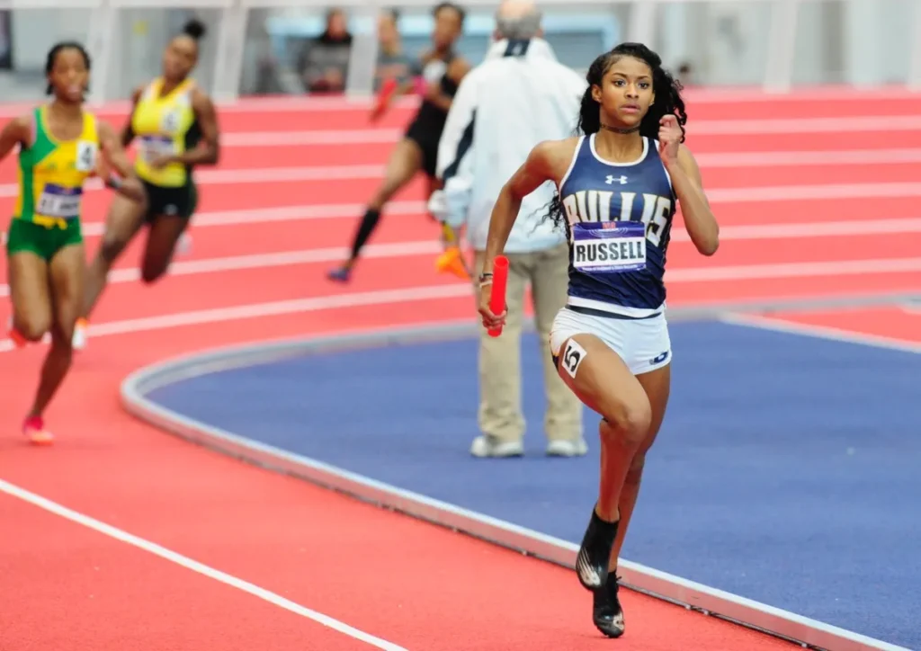 Russell running an indoor relay in high school 