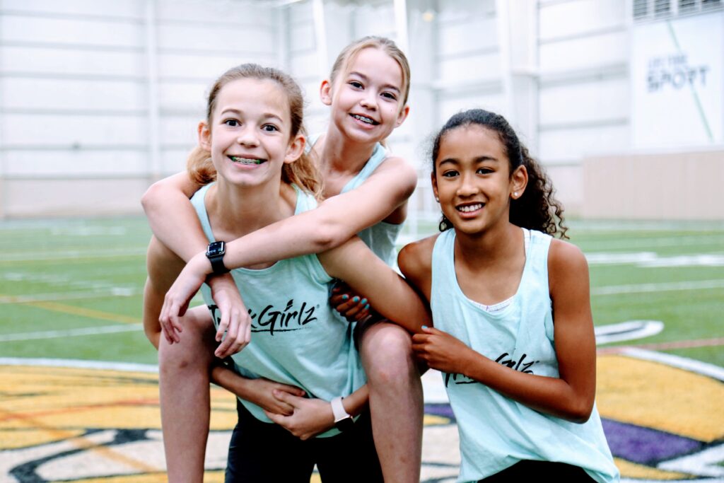 Three girls in TrackGirlz shirts at a workshop