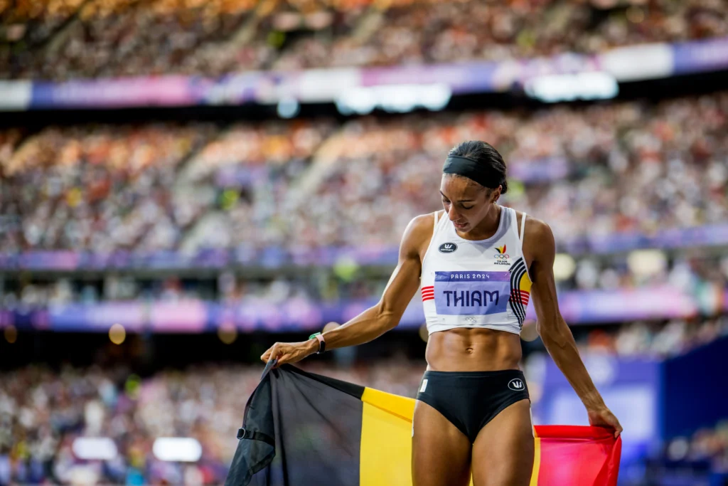 Thiam holds the Belgium flag at the Olympics.